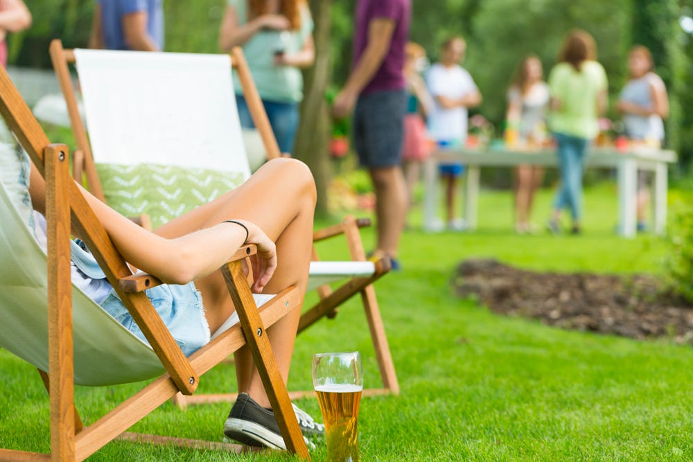 Women sitting on a lawn chair with a beer